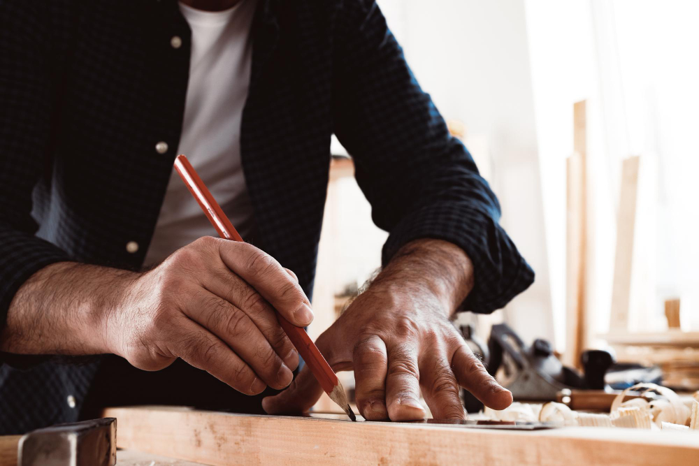 Artisan marking wood with pencil and ruler