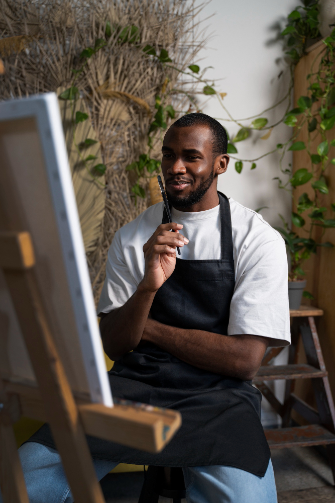 Artist painting at an easel in a studio